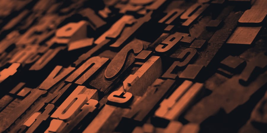 Close-up of wooden letterpress type blocks, individual pieces arranged into a working whole